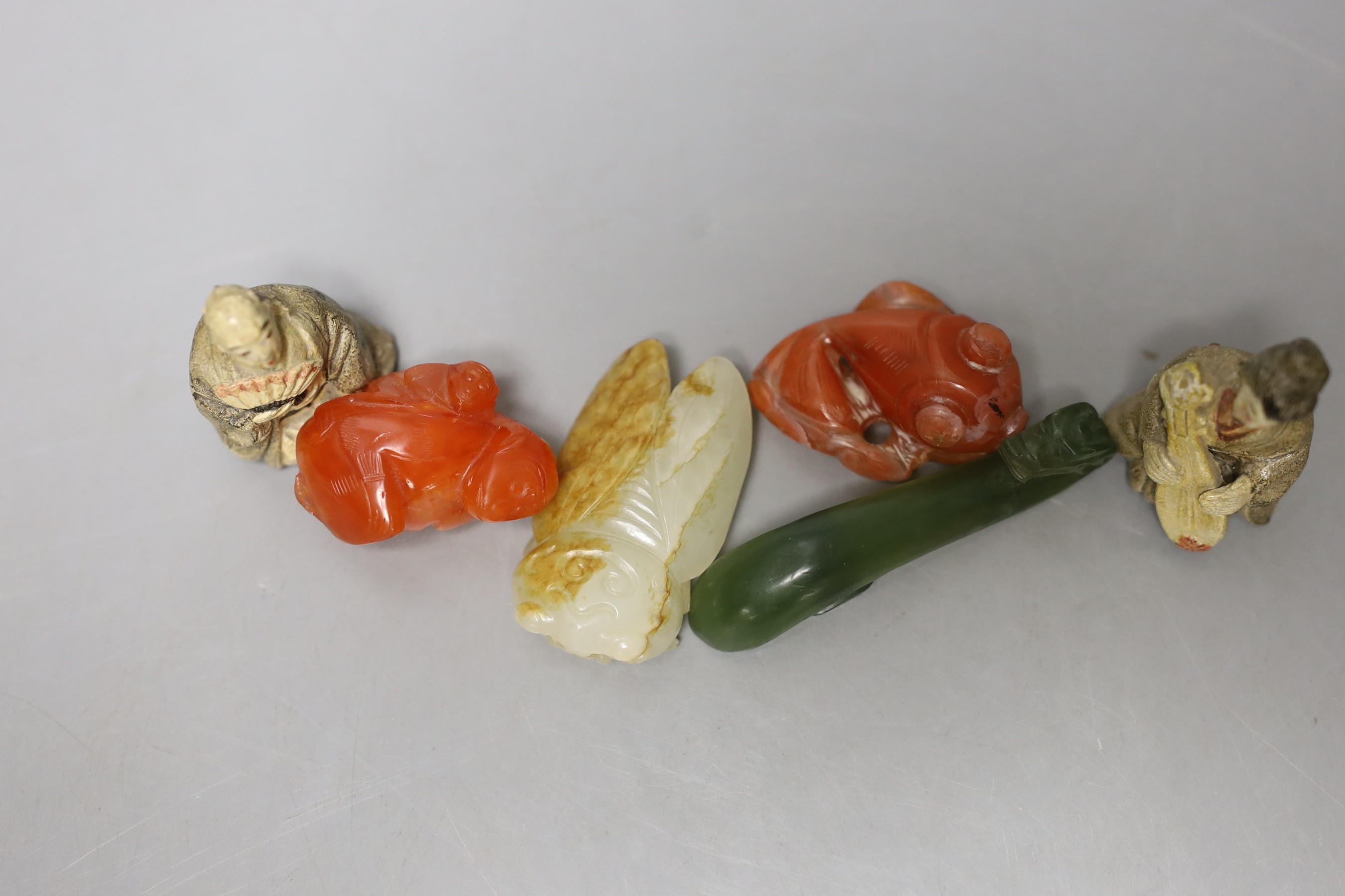 A 19th century Chinese pale celadon and russet jade carving of a cicada, 4.9cm, together with three other hard stone figures and two Japanese earthenware figures (6)